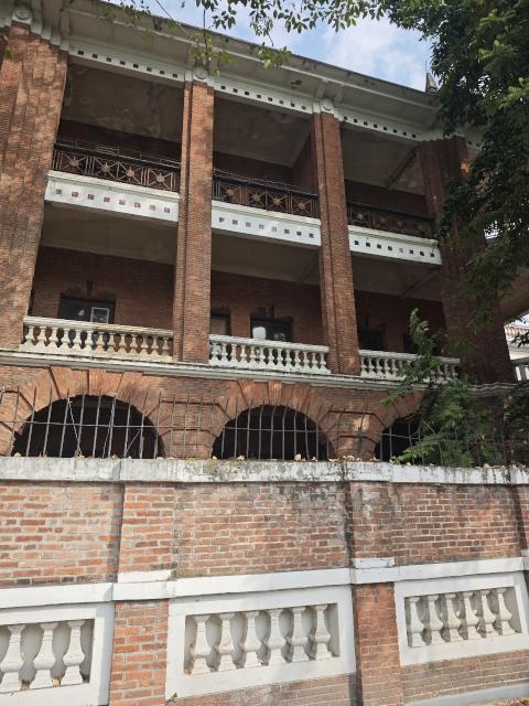 沙面大街68号的红砖立面，三层拱廊与白色栏杆