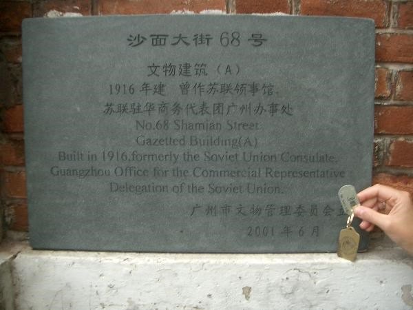 2005年拍摄的铭牌，一只手持旅行虫站在铭牌前