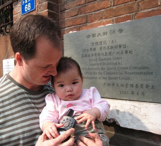 2007年，一位父亲抱着女儿 Natalia 在铭牌前，她手里拿着 GPS