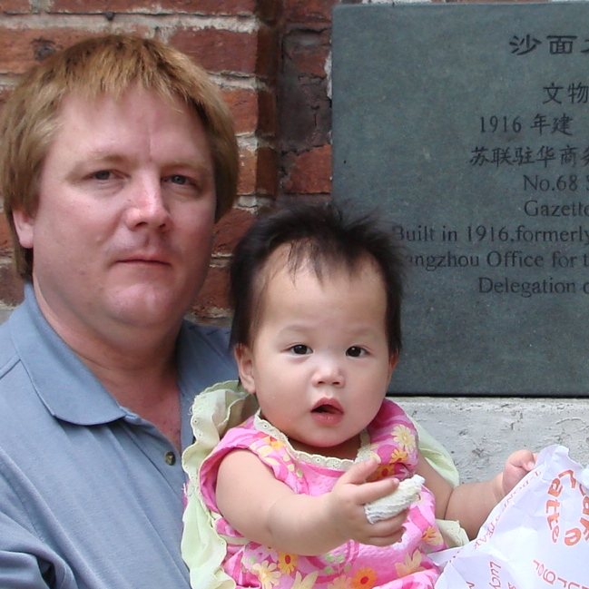 2007年，一位父亲抱着女儿站在沙面大街68号的铭牌前
