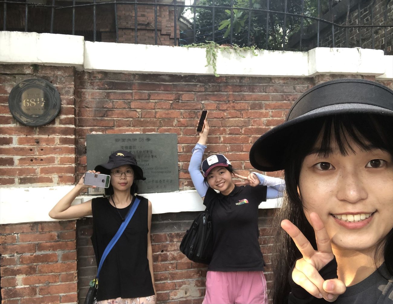 2024年，三位年轻女性在铭牌前举着手机自拍
